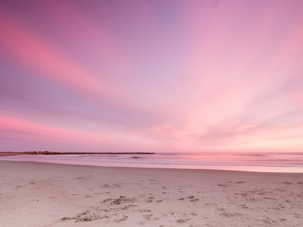 romantic landscape with a pink sunset on the beach