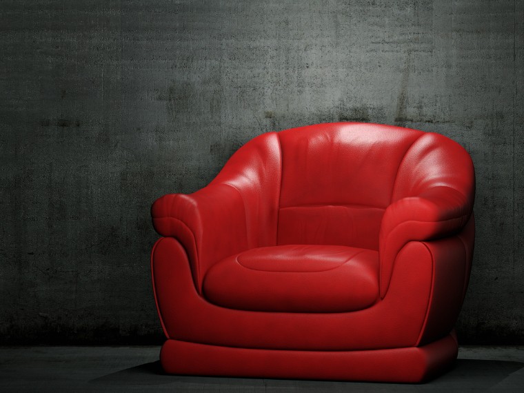 A red armchair in front of a charcoal wall