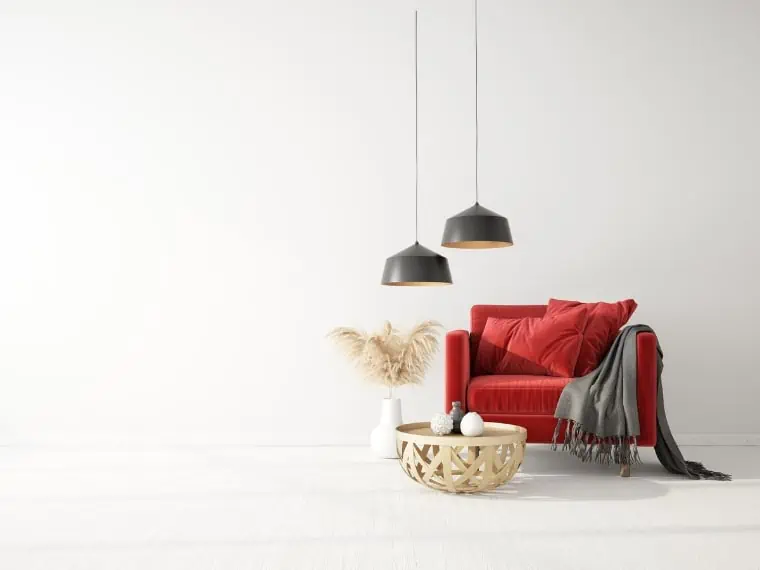 A white cozy living room with red and beige accents