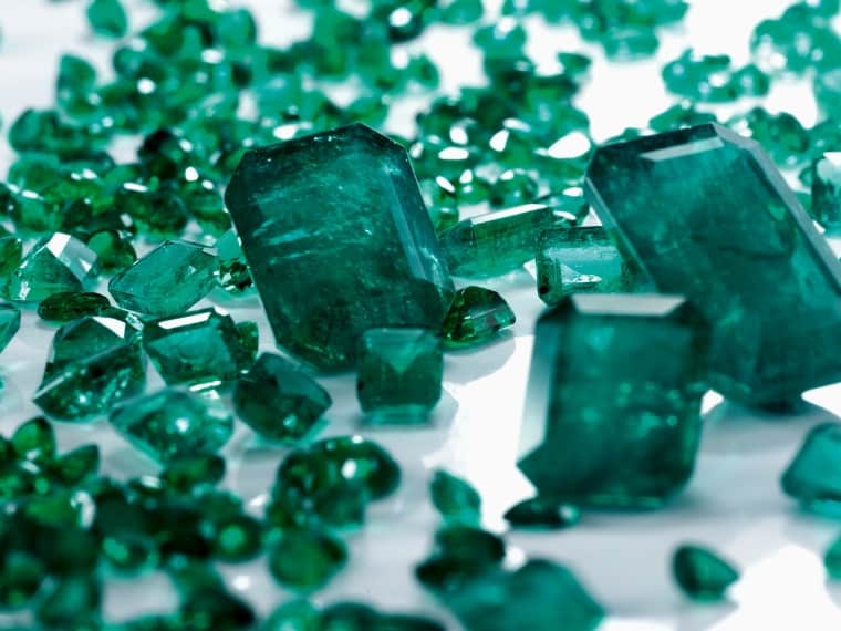 Emerald gemstones on a white surface