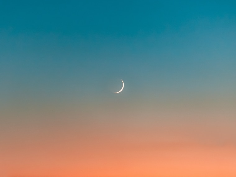Crescent moon in the blue and orange sky
