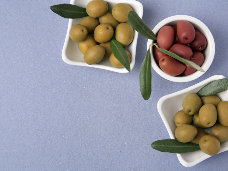 fresh olives on violet background